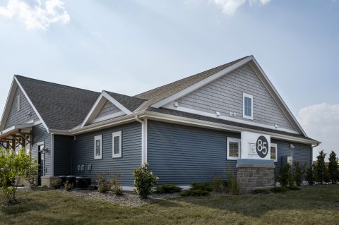Modern blue house with new siding and landscaping by Arrow Exteriors.