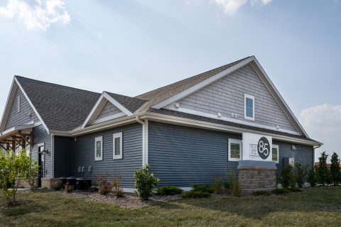 Modern house with blue siding and gray roof at 85 At Maple Grove.