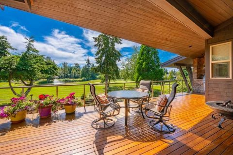 Covered porch with outdoor furniture and scenic landscape view.