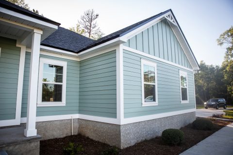 Beautiful light blue house exterior with white trim and black roof.