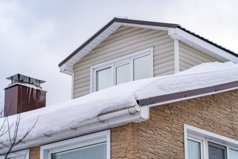 Snow buildup on roof causing potential winter roof problems in Madison.