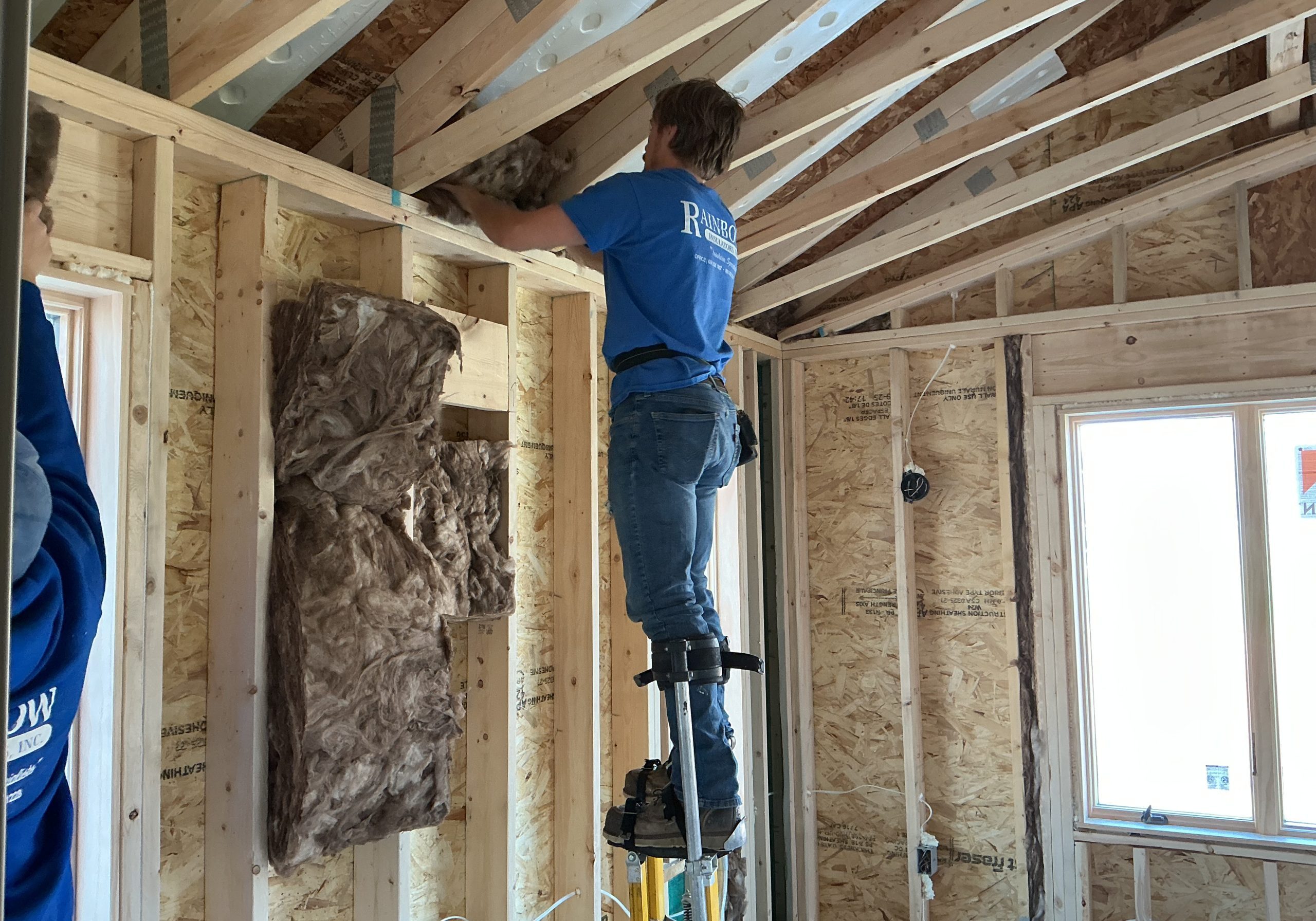 Worker installing insulation in an attic during interior remodeling.