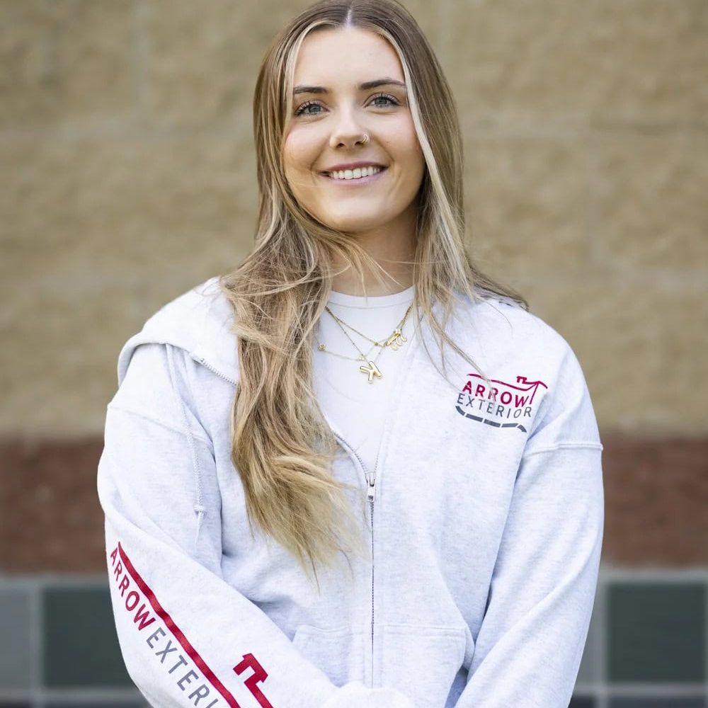 Smiling woman in Arrow Exteriors hoodie for About Us page.
